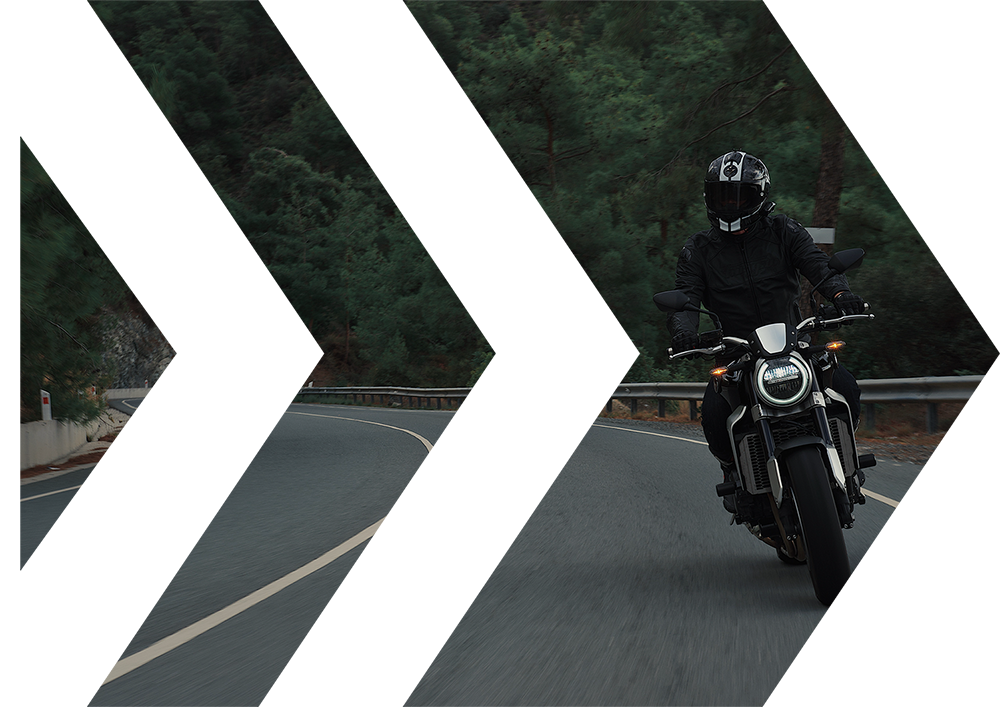 Photo d'un motard sur la route dans une courbe, le tout mis dans une forme de flèche